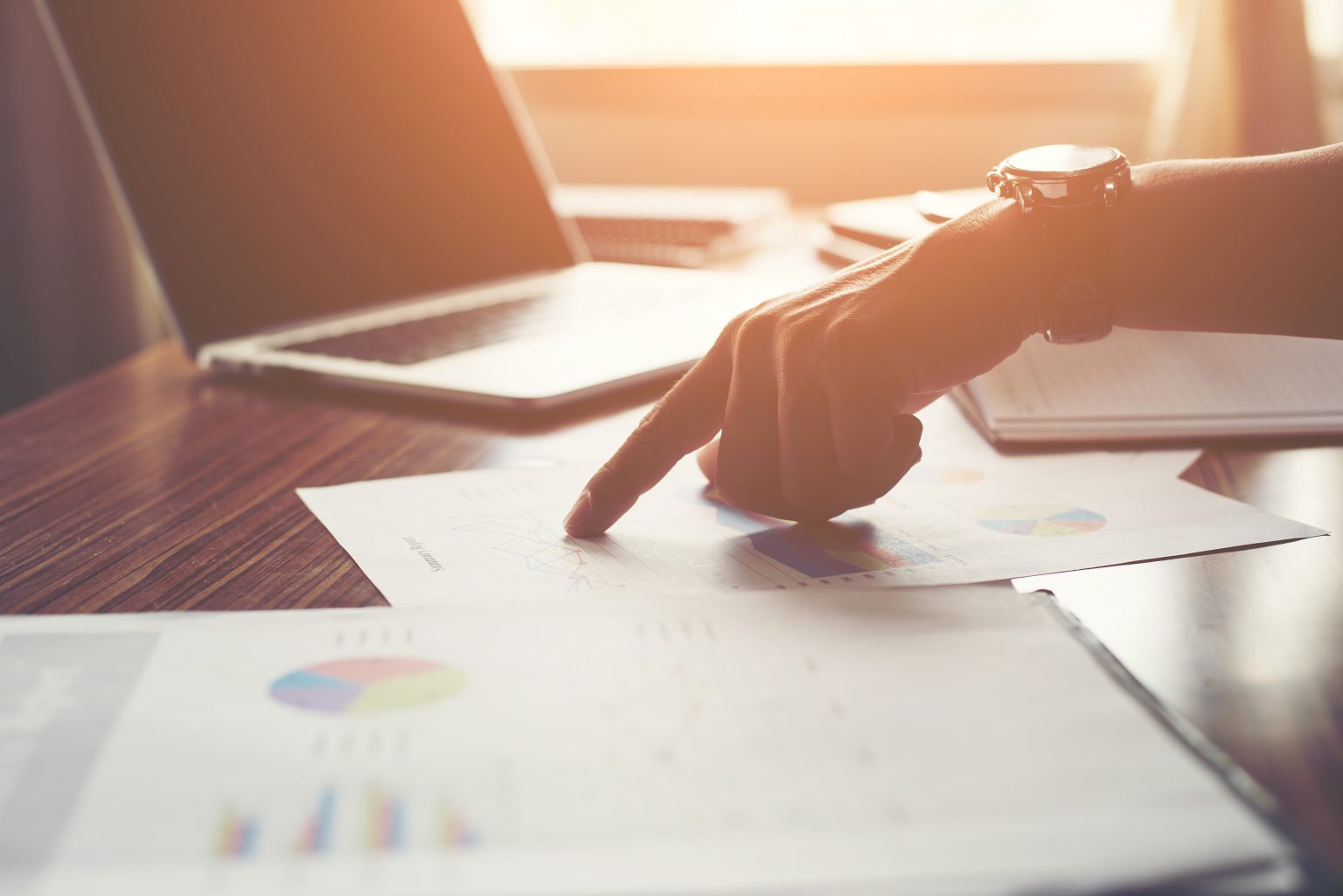 Businessman pointing finger analyzing statistics financial graph.